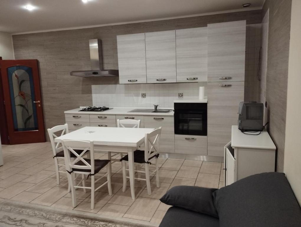 a kitchen with a white table and chairs in a room at Fattoria I Canarini in Fossalta di Piave
