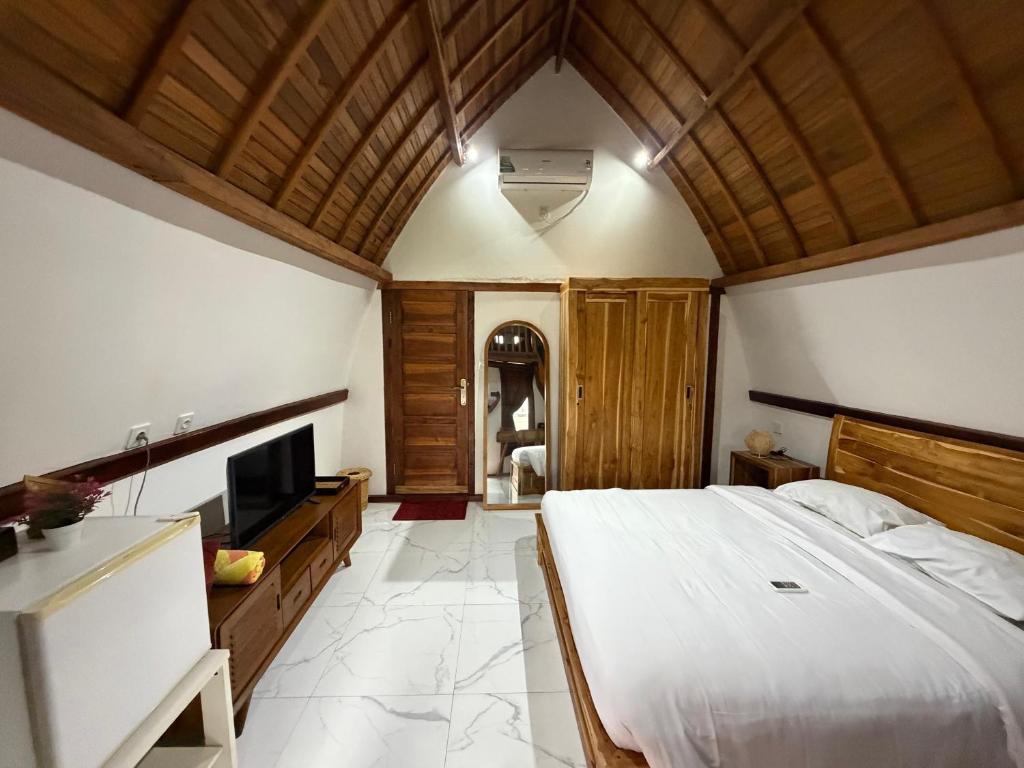a bedroom with a large bed and a television at Villa Aiden Bungalow 3 near luwatu in Ungasan