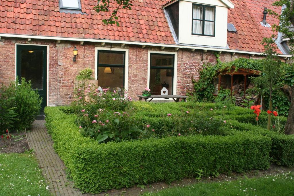 un jardín frente a una casa de ladrillo en Appartement Torenzicht - Leeuwarden en Marssum