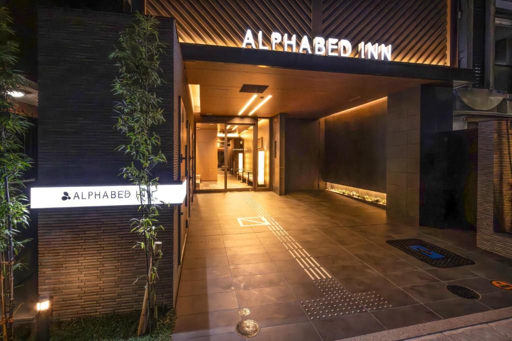 a building with a sign that reads aapped inn at ALPHABED INN Hakata station front in Fukuoka