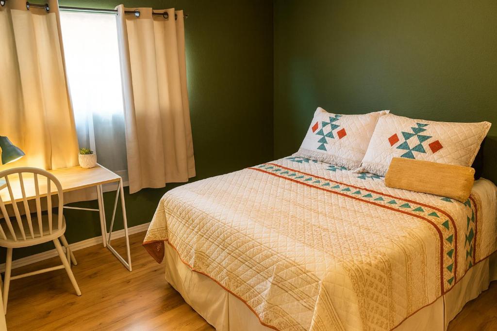a bedroom with a bed with a table and a window at Wildflower Haven room in Hemet
