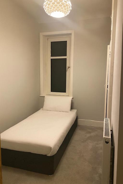 una piccola camera da letto con un letto e una finestra di Simple & Peaceful Space a Colne