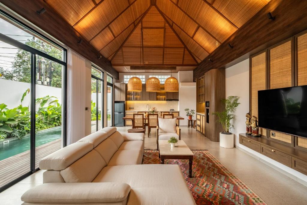 sala de estar de planta abierta con sofá y TV en Villa Mewangi by SooBali Private Pool in Sanur, en Sanur