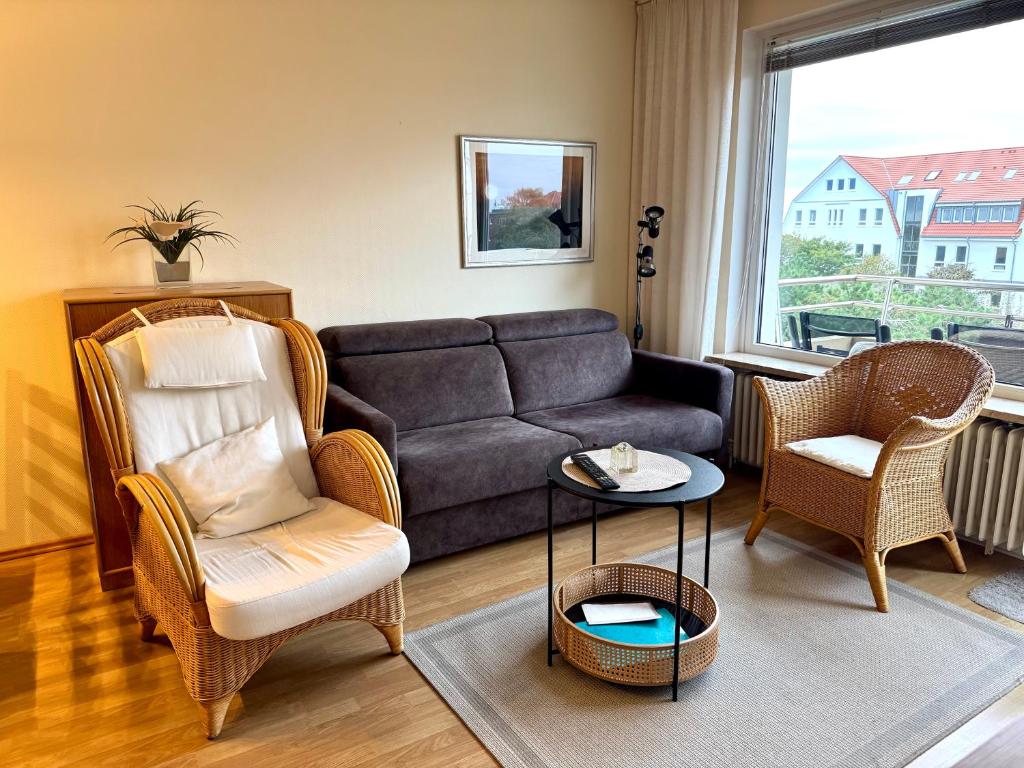 a living room with a couch and two chairs at Dünenschlösschen 22 in Wangerooge