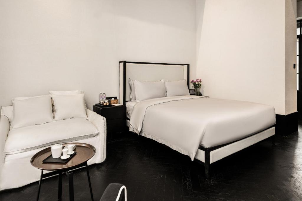 a bedroom with a bed and a couch at 烟台朝阳文保艺术酒店 in Yantai