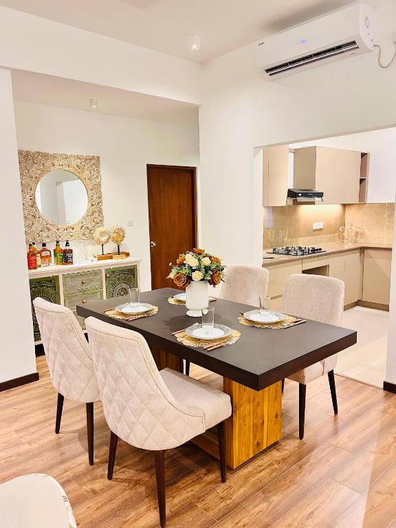 a kitchen and dining room with a table and chairs at The Golfside Luxe in Gonapola