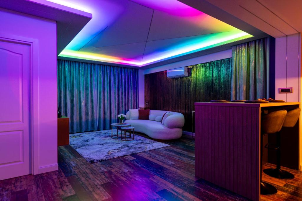 ein Wohnzimmer mit violetten Lichtern und einem Sofa in der Unterkunft VNS LUXURY STAY apartment in Târgovişte