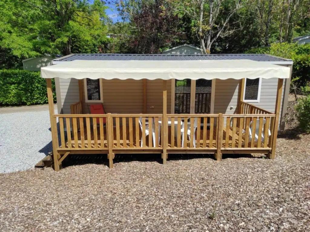 ein winziges Haus mit einer Veranda und einer Markise in der Unterkunft Mobilhome Agora climatisé 50 in Saint-Martial-de-Nabirat