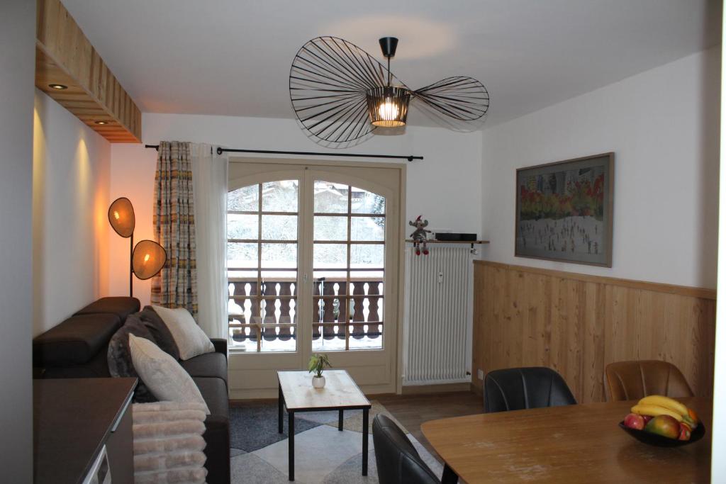 a living room with a couch and a table at Centre, Pistes à pied, Vue magnifique, Calme, Tout renové, Grande terrasse in Les Gets
