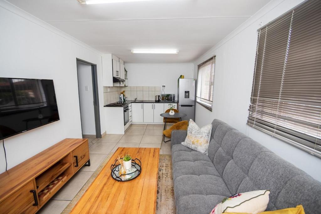 a living room with a couch and a table at Serenity on Geelhaak in Kempton Park