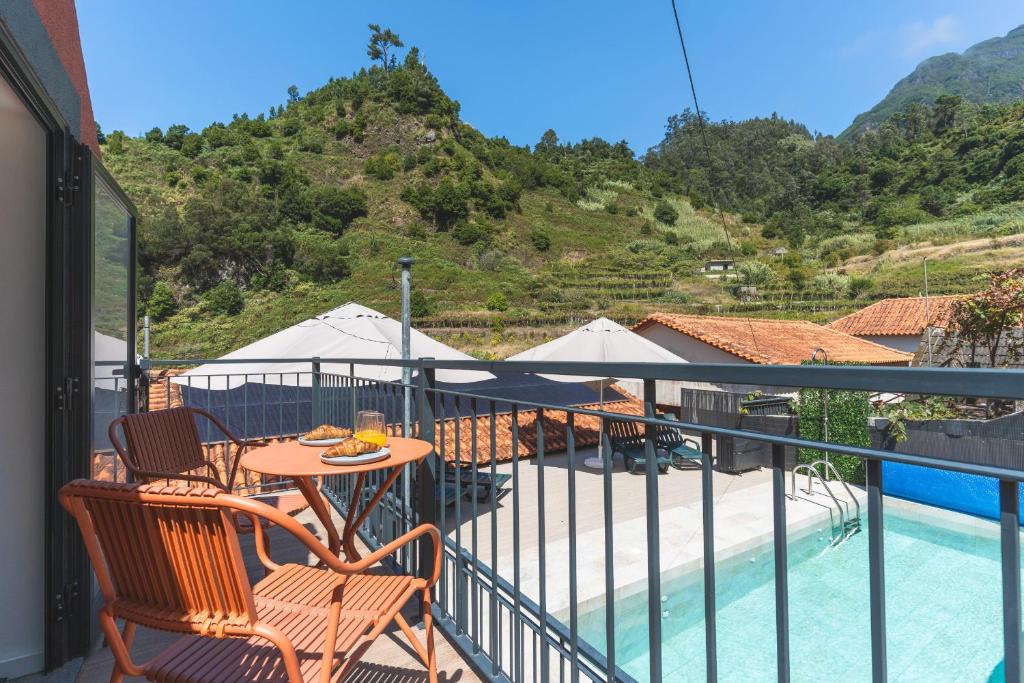 a balcony with a table and chairs and a pool at Avo Maria 2 House by AH in Senhora do Rosário
