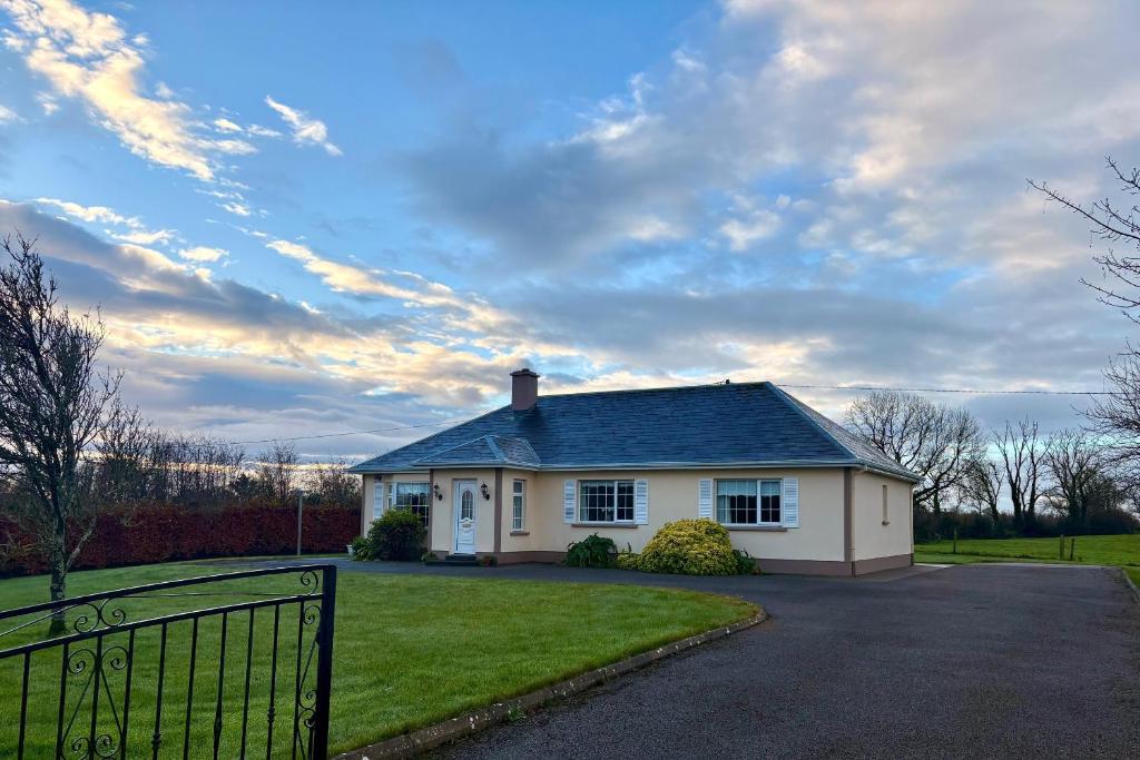 a white house with a fence in front of it at 3 bedroom home close to Athenry in Galway in Athenry
