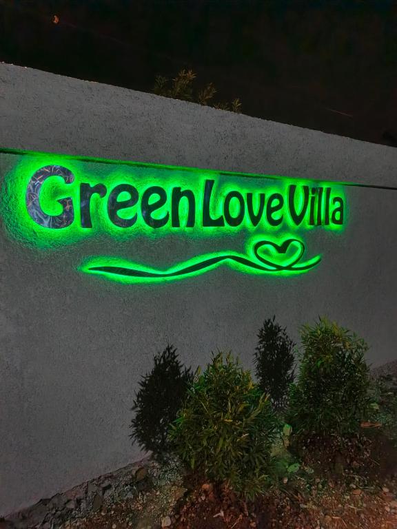 a green lovella sign on the side of a building at Green Love Villa in Pasirmuncang 1