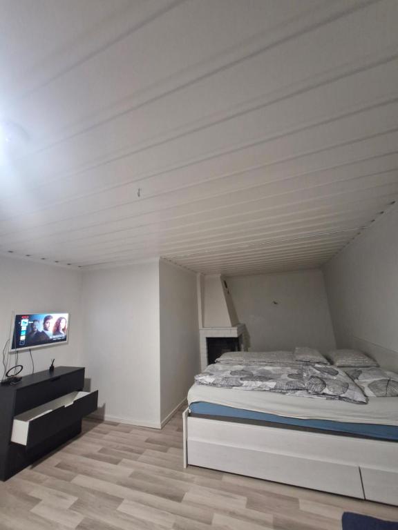 Cette chambre blanche dispose d'un lit et d'une télévision. dans l'établissement Lägenhet i Lindesberg 50kvm, à Lindesberg