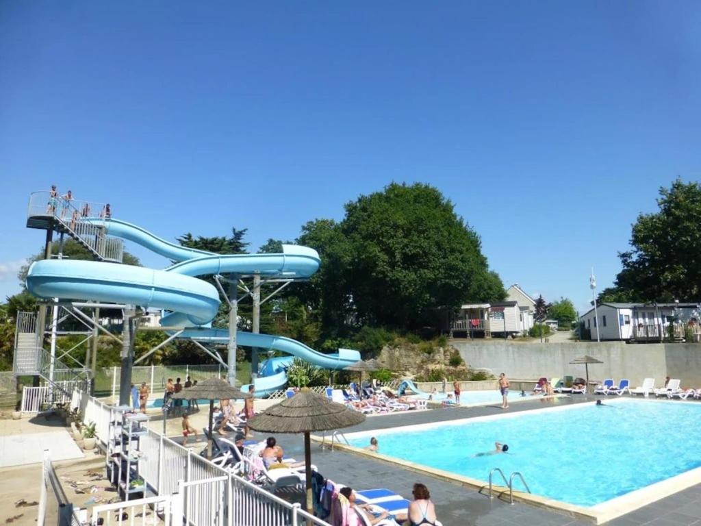 une grande piscine avec un toboggan aquatique dans l'établissement Camping 4 étoiles - Piscine - ccaaeah, à La Baule