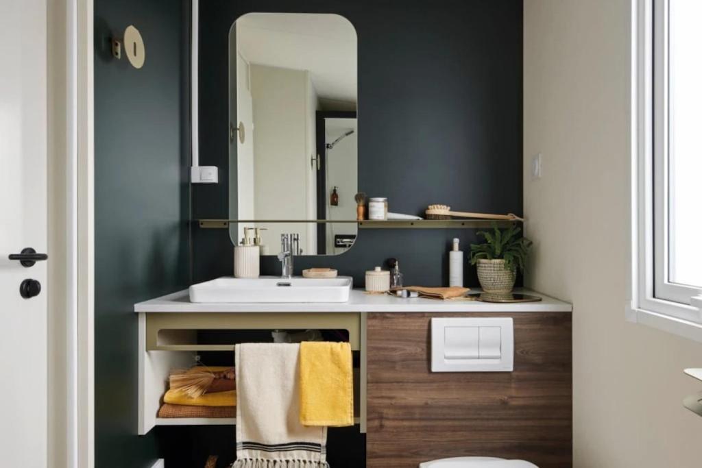 une salle de bains avec un lavabo et un miroir dans l'établissement Camping 4 étoiles - Piscine - ccaaeah, à La Baule