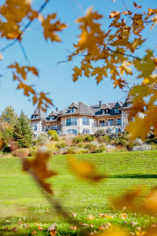 TresservesHôtel L'Incomparable & Restaurant Etoilé Aix-Les-Bains的一座带庭院的大房子