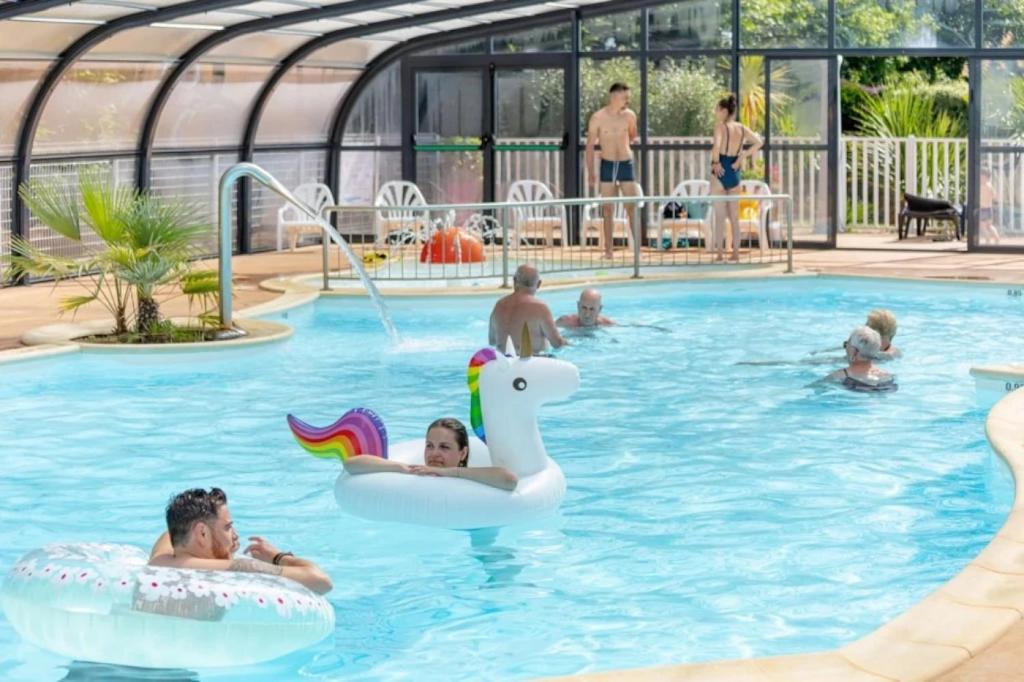 un groupe de personnes nageant dans une piscine dans l'établissement Camping 4 étoiles - Piscine - eec0di, à Fouesnant