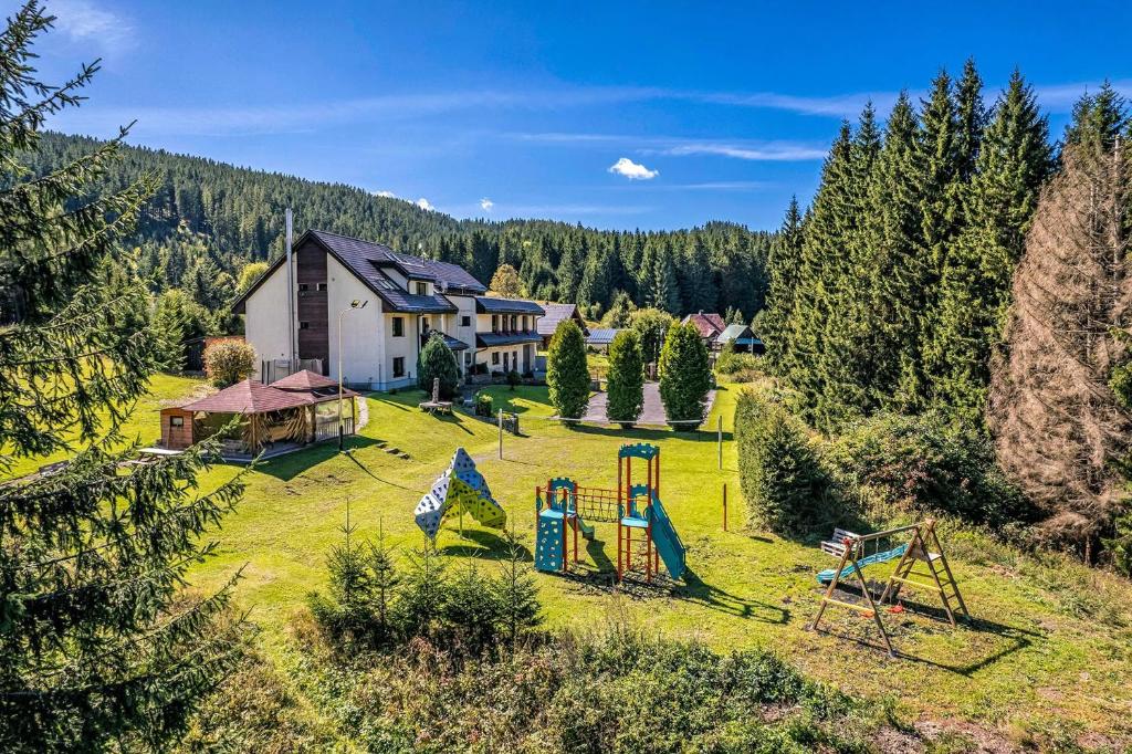 an empty playground in a field with a house at Penzión VODÁR in Donovaly