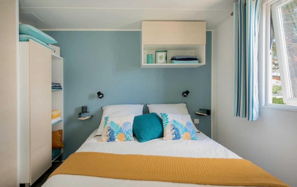- une petite chambre avec un lit aux murs bleus dans l'établissement Camping 5 étoiles - Parc aquatique - eei0fd, à Saint-Jean-dʼOrbetiers