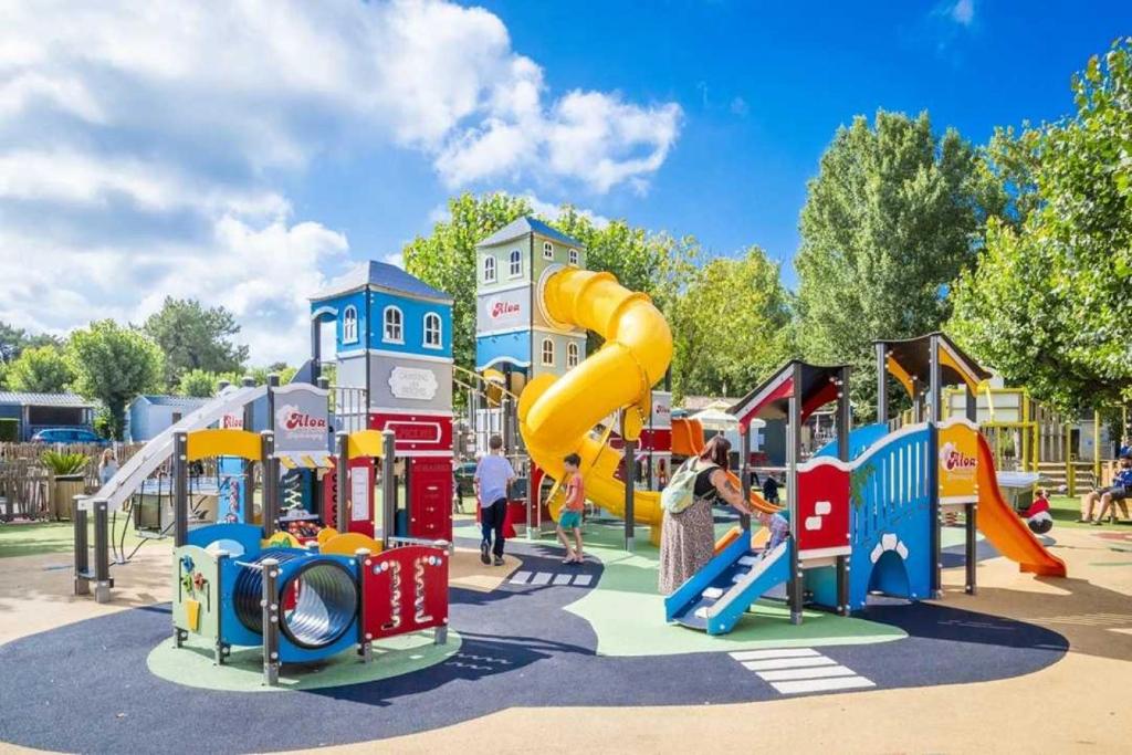 une aire de jeux avec un toboggan dans un parc dans l'établissement Camping 5 étoiles - Parc aquatique - eei0fd, à Saint-Jean-dʼOrbetiers