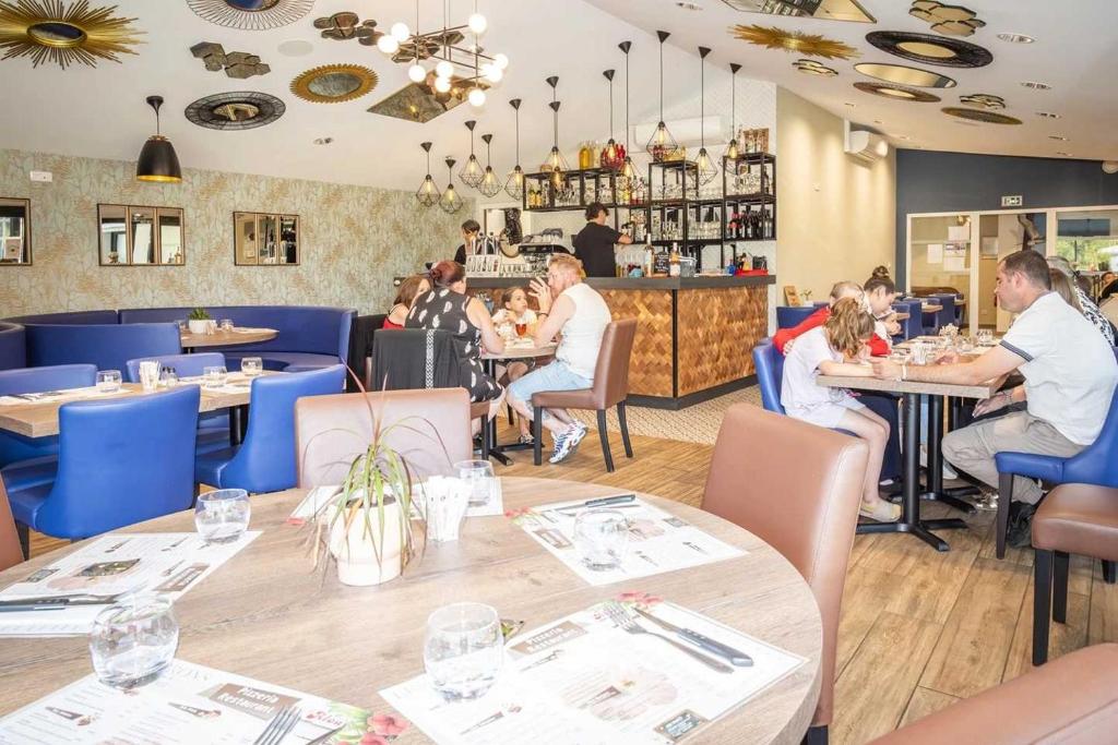 un restaurant avec des gens assis à des tables et un bar dans l'établissement Camping 5 étoiles - Parc aquatique - eei0fd, à Saint-Jean-dʼOrbetiers