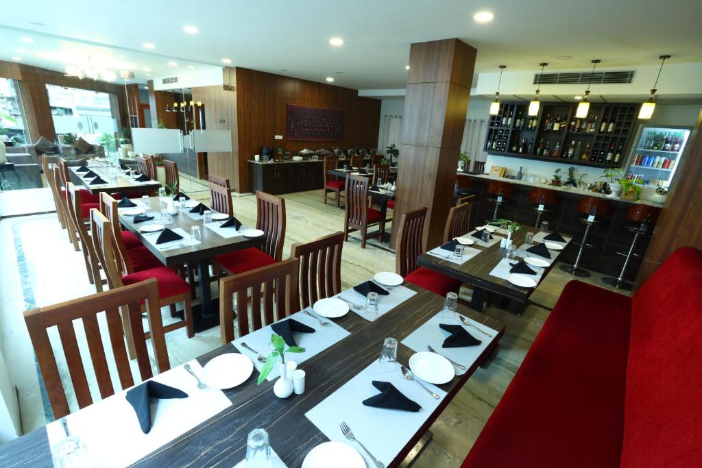 un restaurante con mesas y sillas y un bar en DEWALING by Laughing Lama Hotels, en Phuntsholing