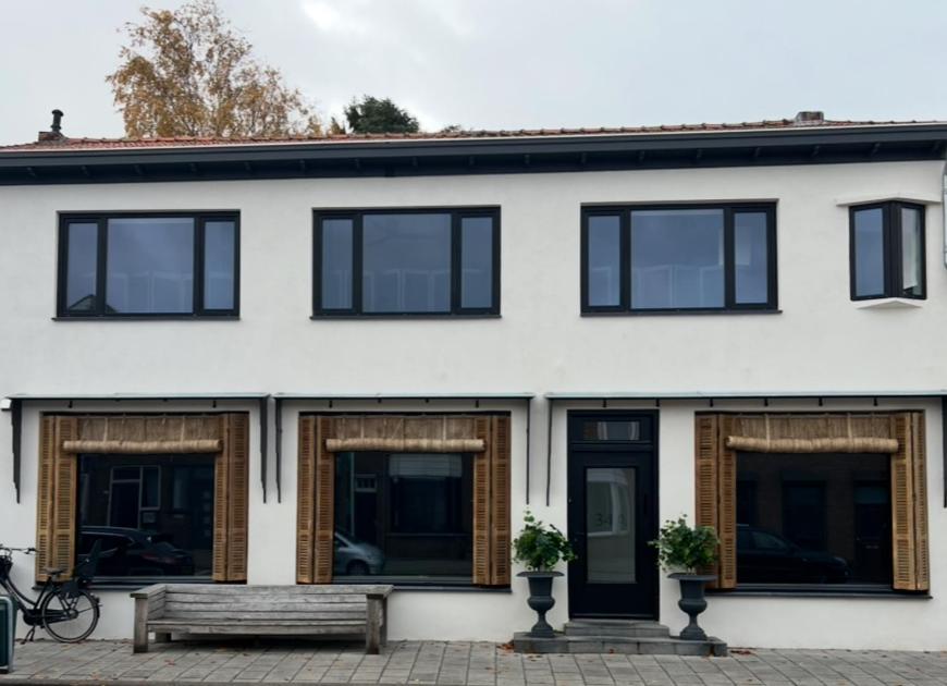 una casa blanca con un banco delante en Studio 3, en Axel