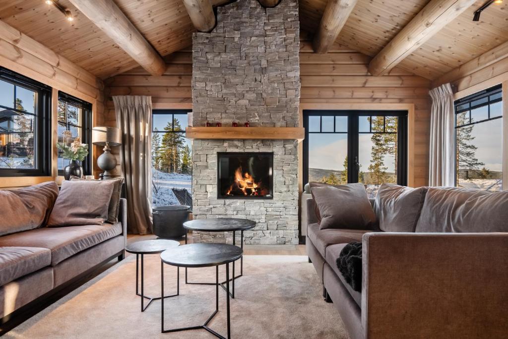 ein Wohnzimmer mit Couch und Kamin in der Unterkunft Trysilsetra 35 in Trysil