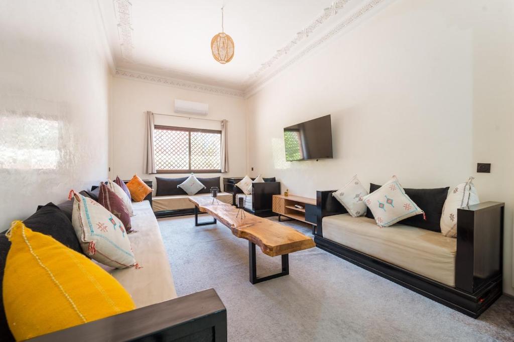 ein Wohnzimmer mit Sofas und einem Couchtisch in der Unterkunft Charming Flat with AC Fast Wifi Secure Residence in Oulad Akkou