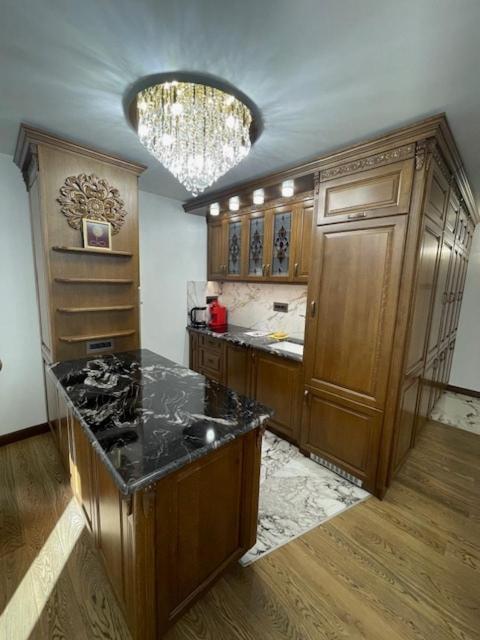 eine Küche mit Holzschränken und einer schwarzen Arbeitsplatte in der Unterkunft Luxury Apartment Downtown Blagoevgrad in Blagoewgrad