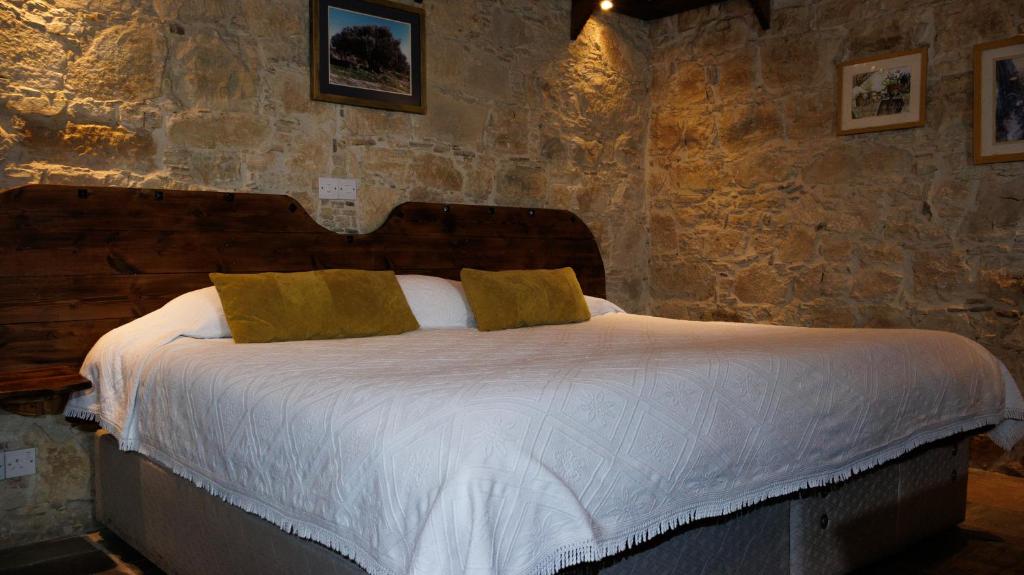 a bedroom with a large bed in a stone wall at Agrovino Lofou in Lofou