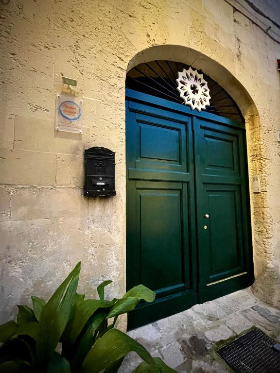 a green door with a wreath on a building at Dimora Antonia in Lecce