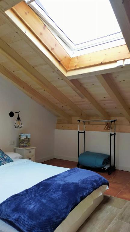 a bedroom with a bed and a skylight at Casa iulia in Haro