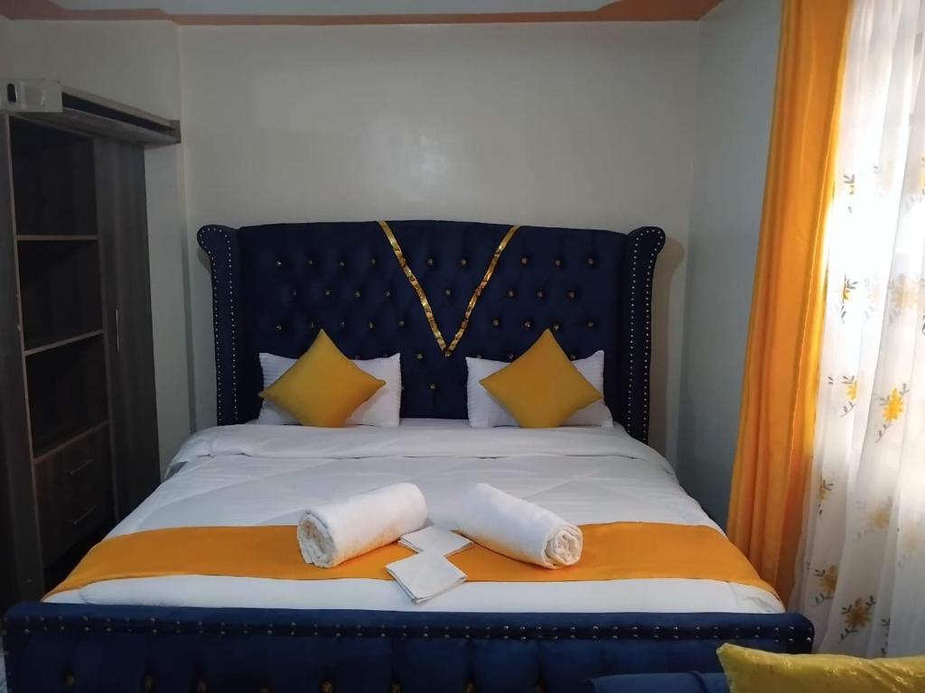 a blue bed with two white towels on it at Flomark in Nairobi