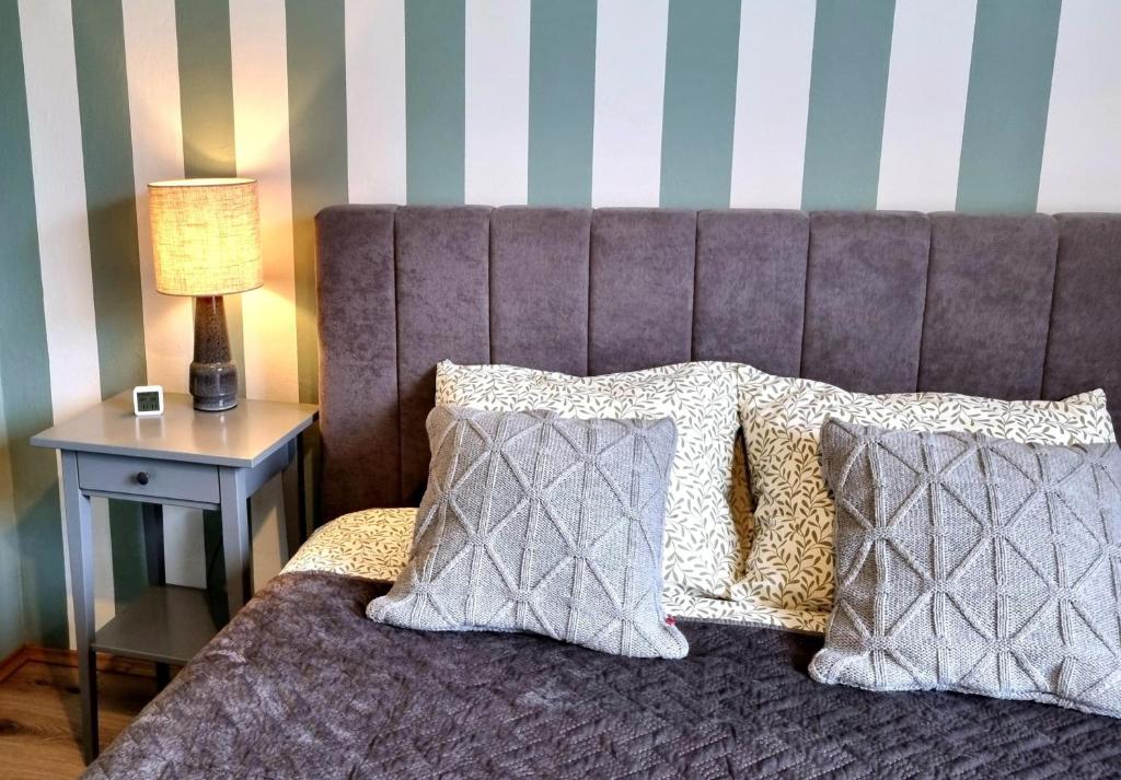 a bed with two pillows and a table with a lamp at Apartament Akacja CENTRUM in Rzeszów