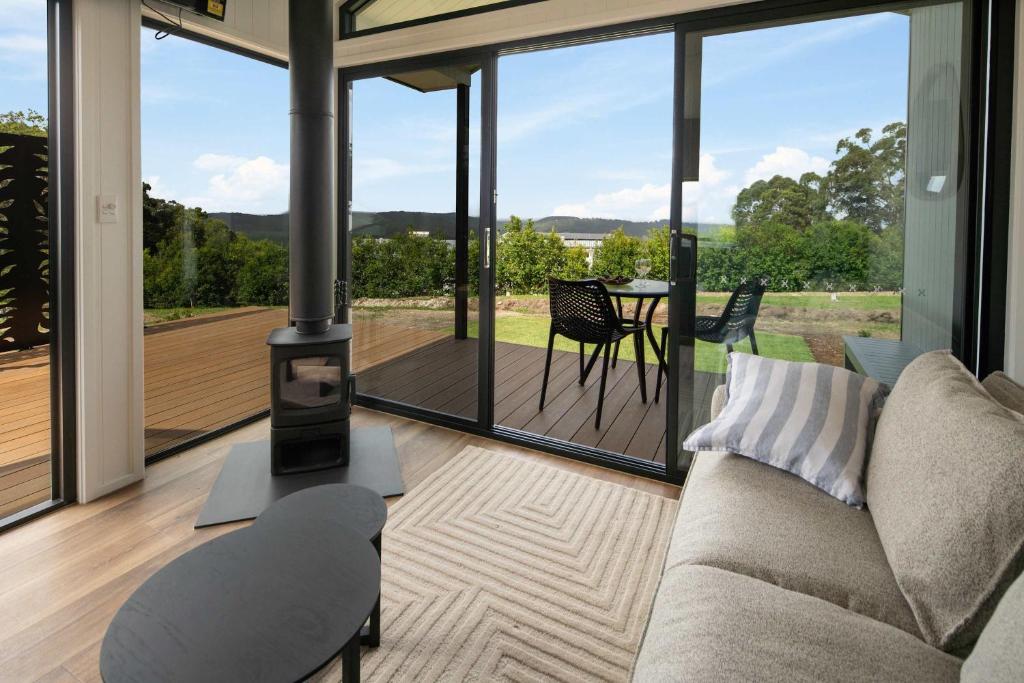 a living room with a couch and a wood stove at Grevillea Villa in Valdora
