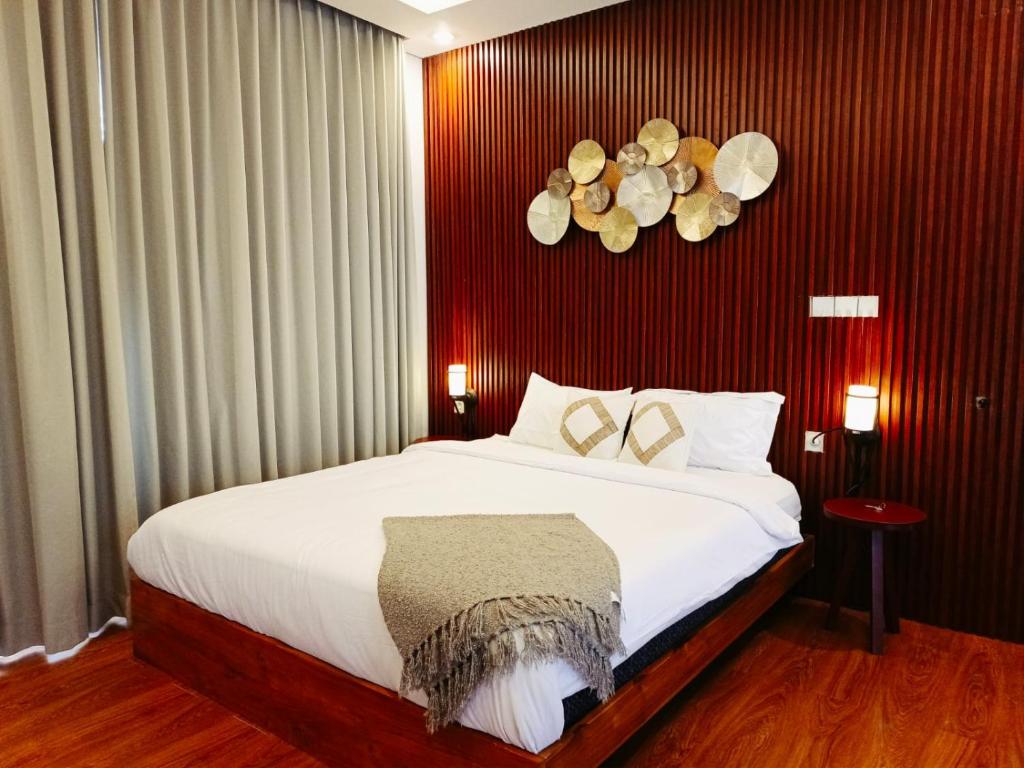 ein Schlafzimmer mit einem großen Bett mit einer roten Wand in der Unterkunft Apartment De Palm in Uluwatu