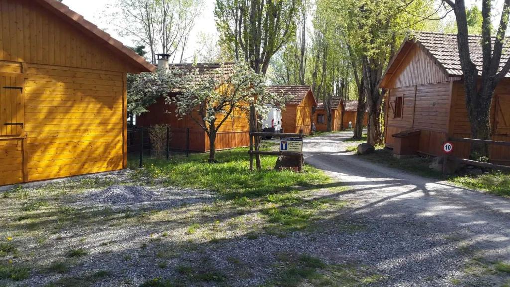 a row of wooden buildings on a dirt road at Chalet 2 étoiles - ef0bde in Neffes