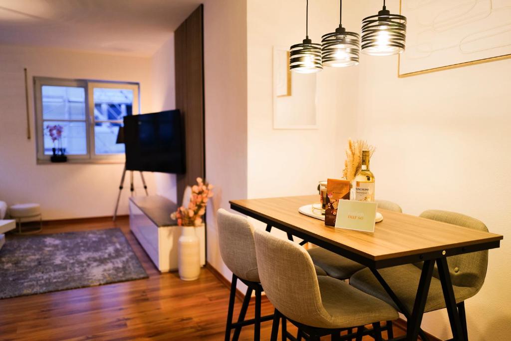ein Esszimmer und ein Wohnzimmer mit Tisch und Stühlen in der Unterkunft Modern Apartment near Therme Erding WIFI in Erding