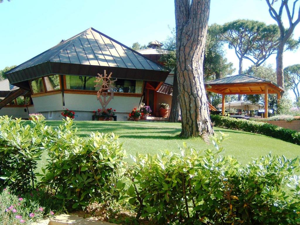 プンタ・アーラにあるDamiani Experience La Bussola - NEW 2024の木の植わる緑の庭のある家