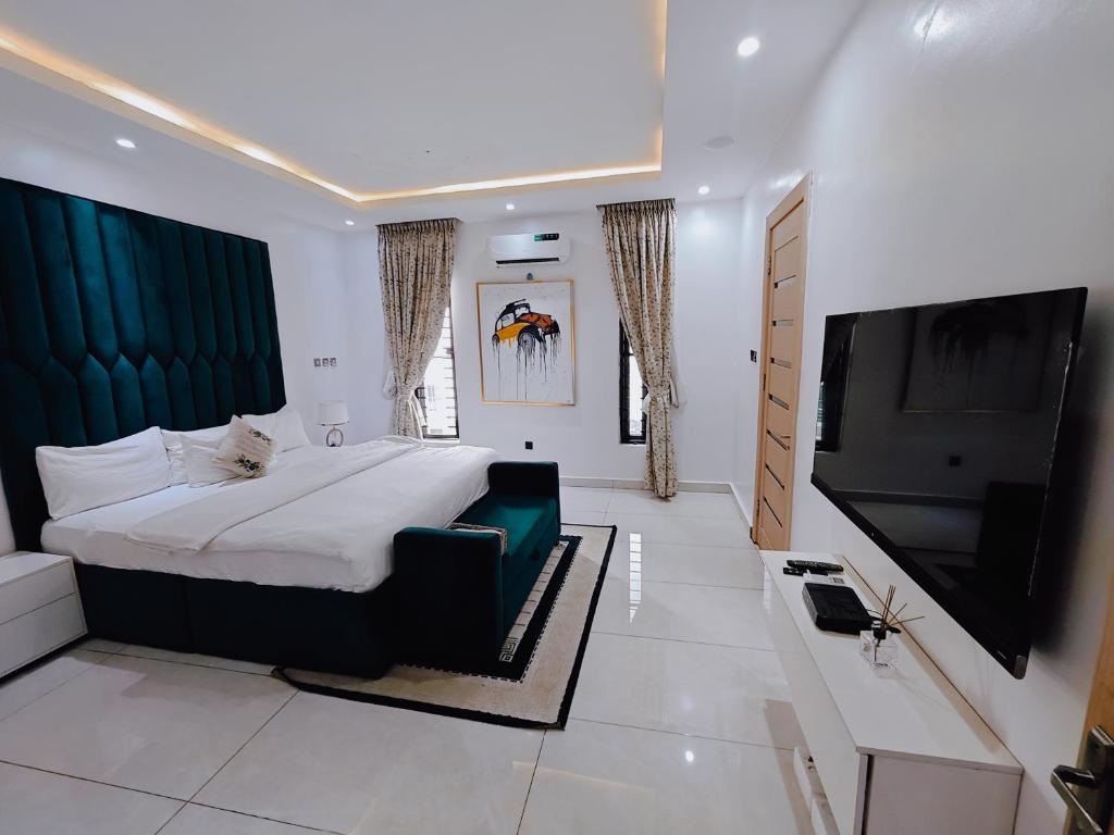 a bedroom with a large bed and a flat screen tv at Sahara Apartment Ikoyi in Lagos