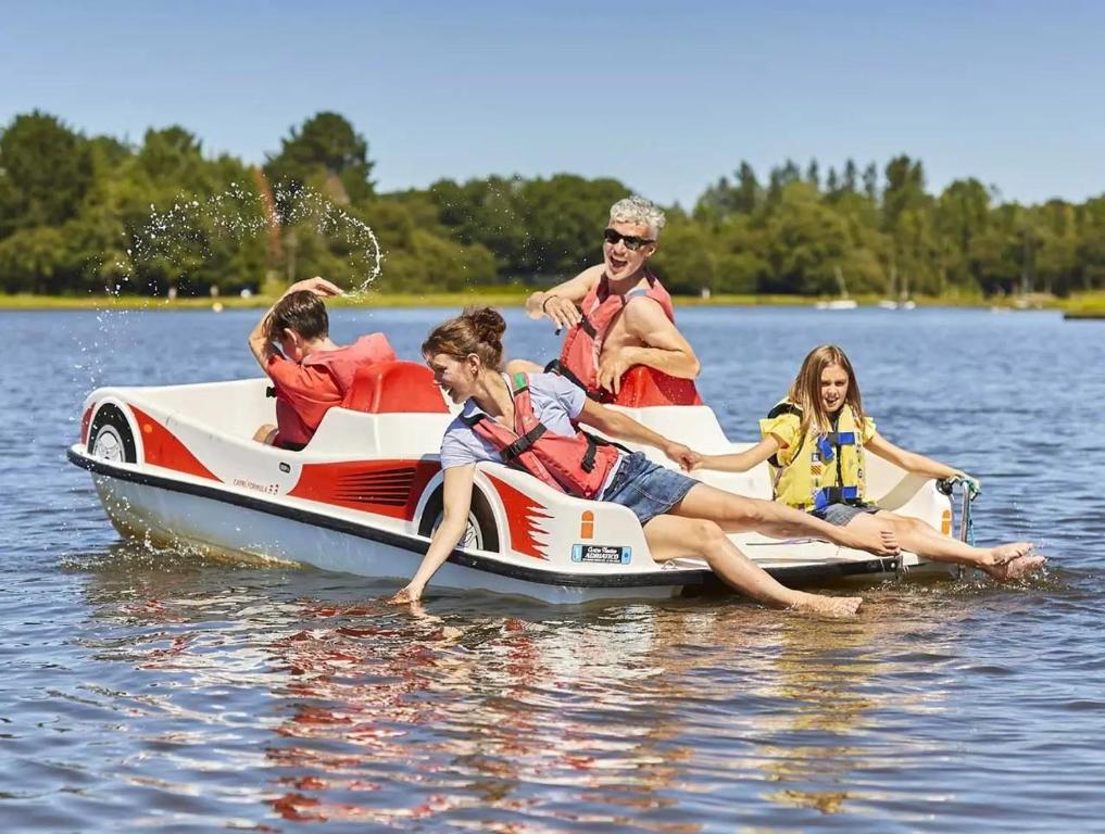 a group of people sitting on a boat in the water at ZEcamping 3 étoiles pet friendly avec sauna bar et restaurant in Priziac