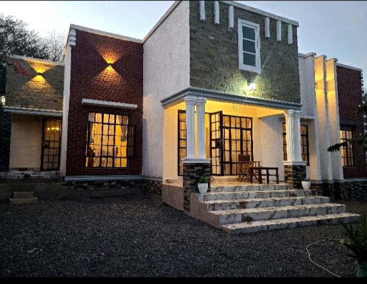 ein großes Haus mit Treppe davor in der Unterkunft Pumzika hill homes in Arusha