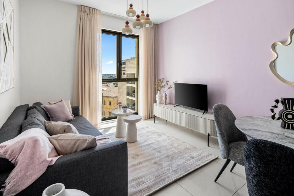 Μια τηλεόραση ή/και κέντρο ψυχαγωγίας στο Cozy 1BR next Mahane Hayeuda