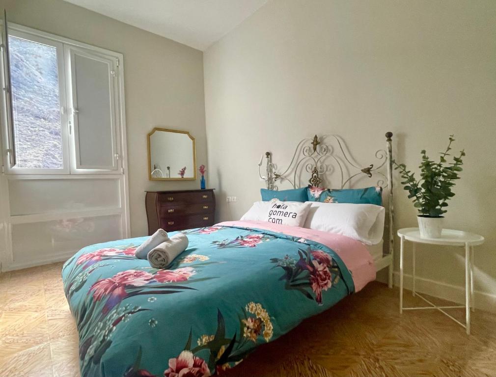 een slaapkamer met een bed met een bloemenbed bij Casa Orijamas in Calera