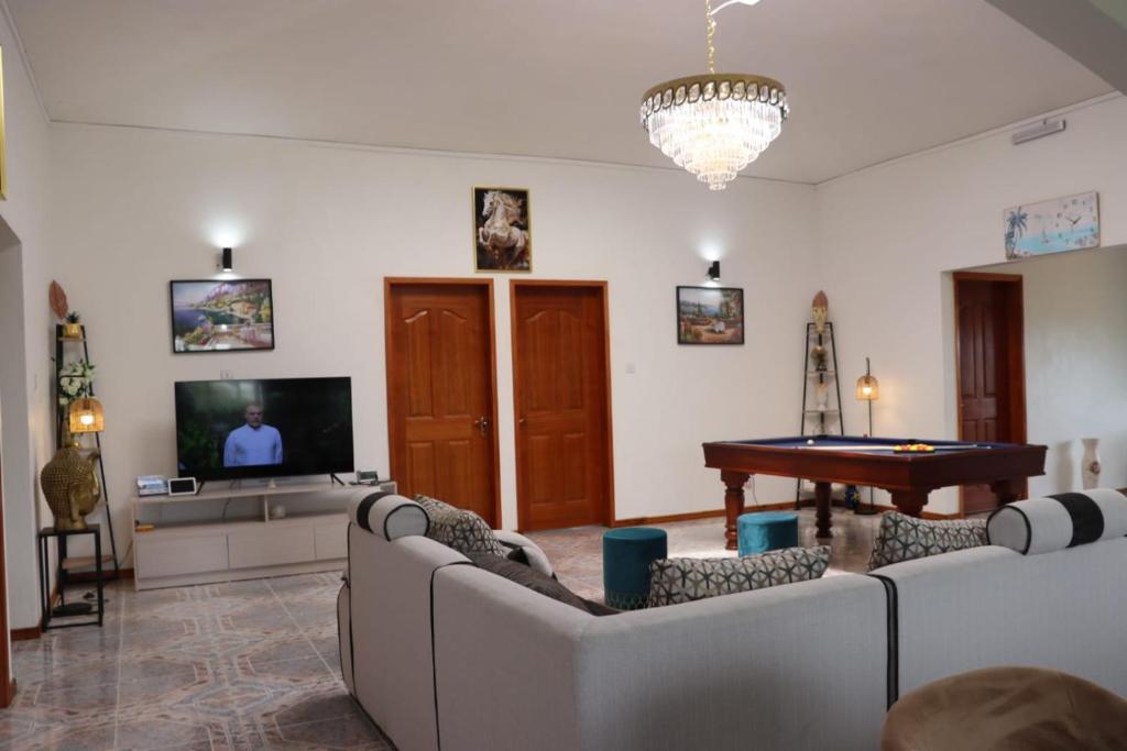 a living room with couches and a pool table at Panoramic Seaview suite in Trou d'Eau Douce