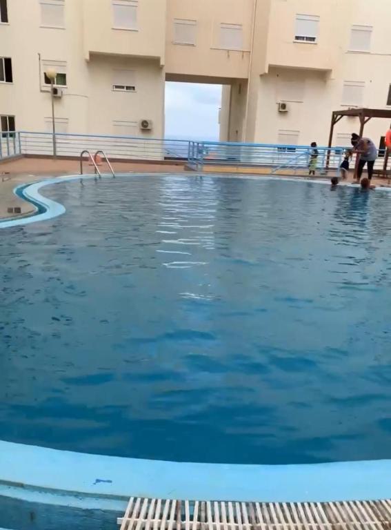 a swimming pool with blue water in a building at Condominio atlantico ll in Praia