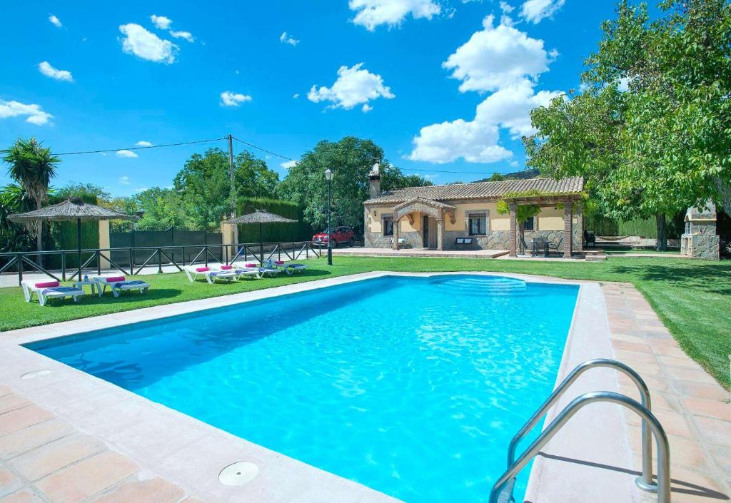 une piscine dans une cour avec une maison dans l'établissement El Nogal, à Arriate