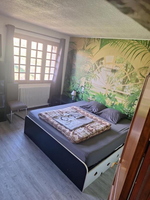 une chambre avec un grand lit avec une fresque sur le mur dans l'établissement Maison au milieu des vignes, à Moroges